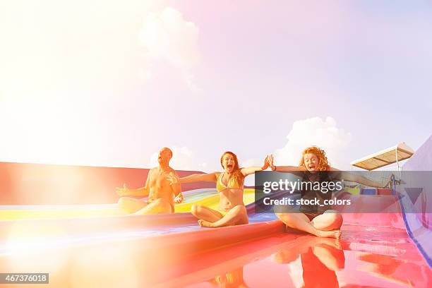 friends on water slide laughing - waterslide stock pictures, royalty-free photos & images