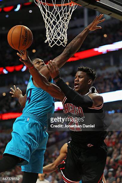 Jimmy Butler of the Chicago Bulls passes around Jason Maxiell of the Charlotte Hornets at the United Center on March 23, 2015 in Chicago, Illinois....
