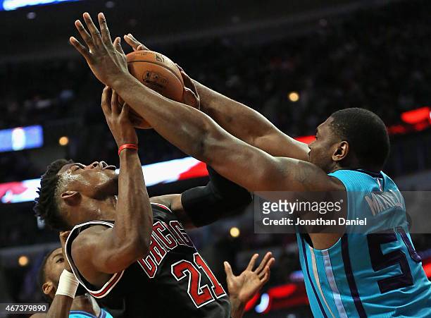 Jimmy Butler of the Chicago Bulls is fouled while shooting by Jason Maxiell of the Charlotte Hornets at the United Center on March 23, 2015 in...