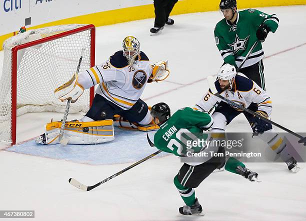Cody Eakin of the Dallas Stars scores a goal against Anders Lindback of the Buffalo Sabres as Mike Weber of the Buffalo Sabres defends in the third...