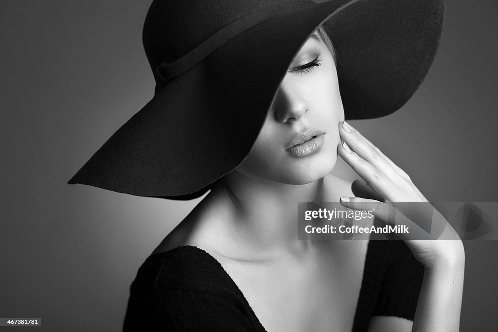 Giovane bella donna con cappello nero