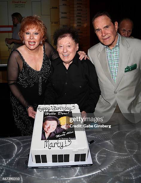 Entertainer Karon Kate Blackwell, her husband, actor/comedian Marty Allen and impressionist Rich Little hold up a cake to celebrate Allen's 93rd...