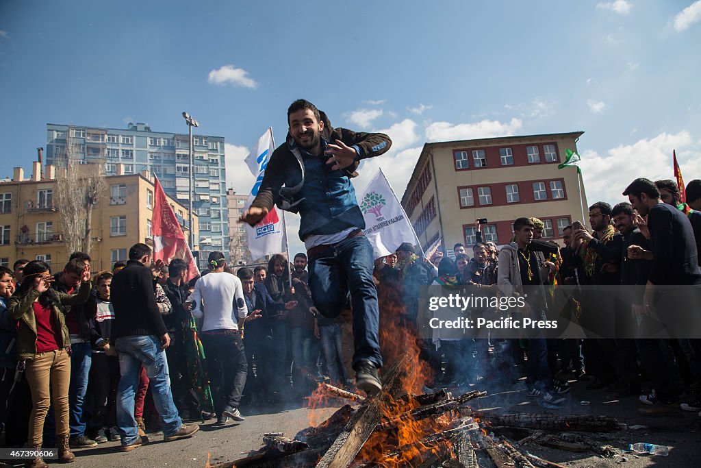 A man jumps over the fire at the Newroz celebration rally.