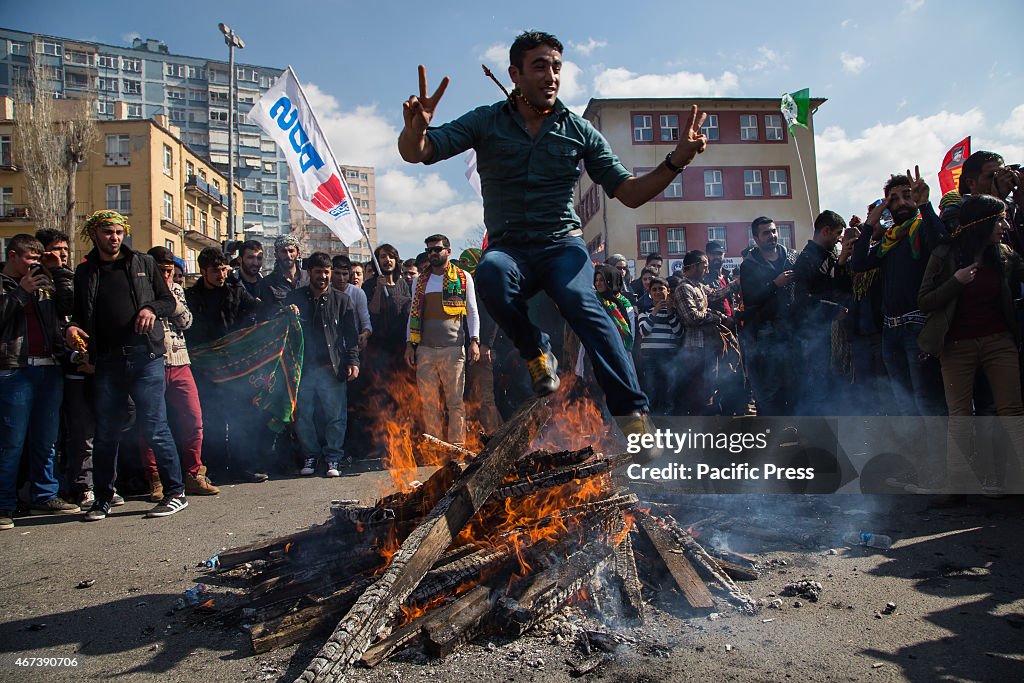 A man jumps over the fire at the Newroz celebration rally.