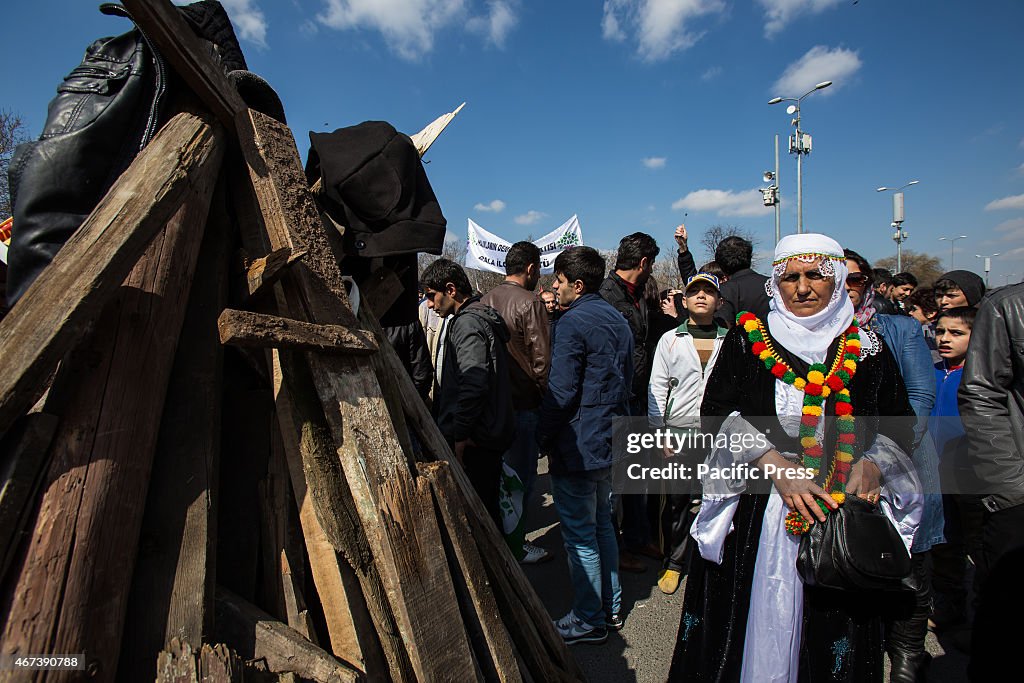 A woman in traditional Kurdish costume look at the pile of...