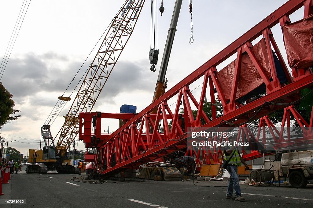 Construction workers set-up a crane to remove the collapsed...