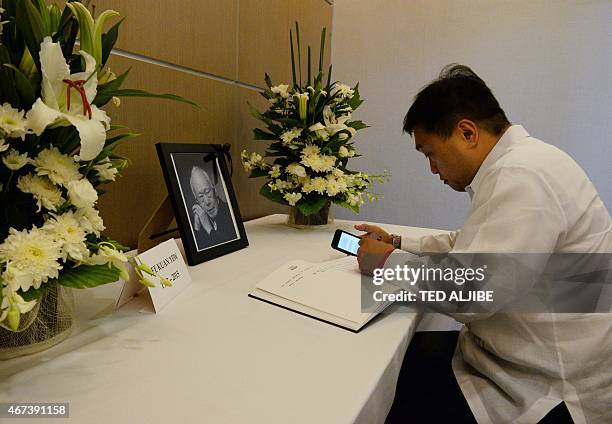 Philippine Finance Secretary Cesar Purisima signs a condolence book in front of a portrait of the late and former Singaporean prime minister Lee Kuan...