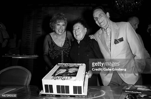 Entertainer Karon Kate Blackwell, her husband, actor/comedian Marty Allen and impressionist Rich Little hold up a cake to celebrate Allen's 93rd...