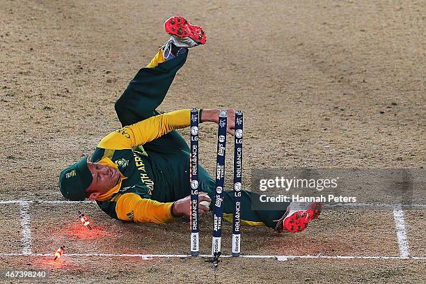 De Villiers of South Africa falls over the stumps during the 2015 Cricket World Cup Semi Final match between New Zealand and South Africa at Eden...