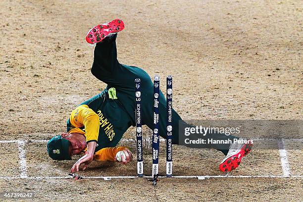 De Villiers of South Africa falls over the stumps during the 2015 Cricket World Cup Semi Final match between New Zealand and South Africa at Eden...