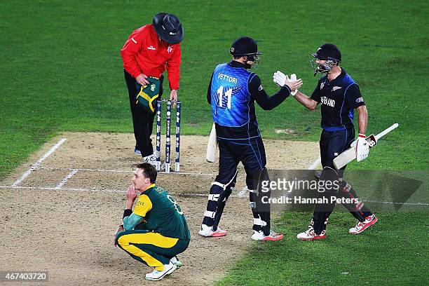 Dale Steyn of South Africa looks on as Daniel Vettori of New Zealand and Grant Elliott of New Zealand celebrate winning the 2015 Cricket World Cup...
