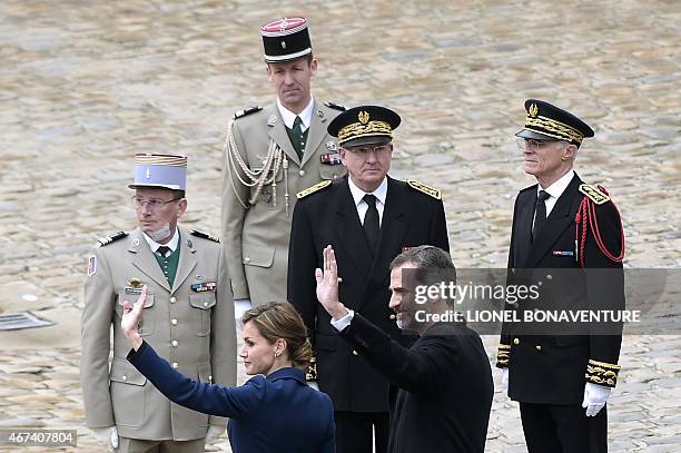 Spain's King Felipe VI and Spain's Queen Letizia wave next to Paris police Prefect Bernard Boucault during a ceremony at the Hotel des Invalides in...