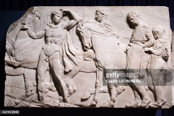 Section of marble frieze sculpture from the Parthenon in Athens, part of the collection that is popularly referred to as the Elgin Marbles, is...