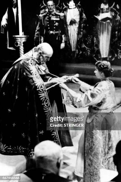 Archbishop of Canterbury Geoffrey Fisher presents on June 2, 1953 Britain's Queen Elizabeth II with a sword, prior to the Coronation ceremony in...