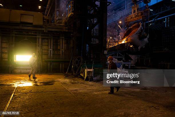 Workers stand by as molten copper flows from a ladle into a furnace at the KHGM Polska Miedz SA copper smelting plant in Glogow, Poland, on Monday,...