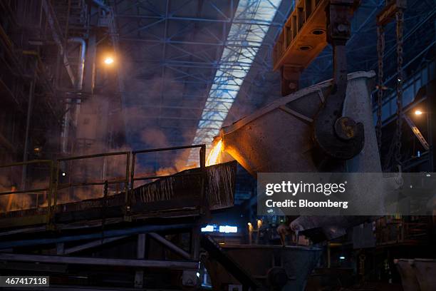 Molten copper flows from a ladle during the manufacture of copper cathode sheets at the KHGM Polska Miedz SA copper smelting plant in Glogow, Poland,...