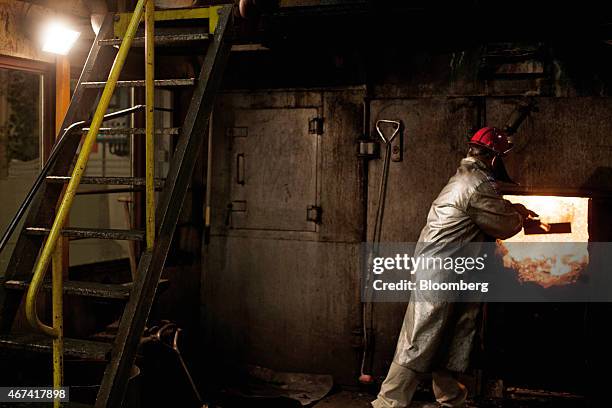 Worker wears heat protective clothing as he checks a furnace at the KHGM Polska Miedz SA smelting plant in Glogow, Poland, on Monday, March 23, 2015....