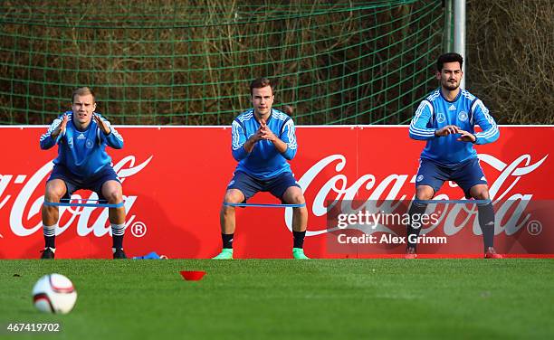 Holger Badstuber, Mario Goetze and Ilkay Guendogan attend a Germany training session at Kleine Kampfbahn training ground on March 24, 2015 in...