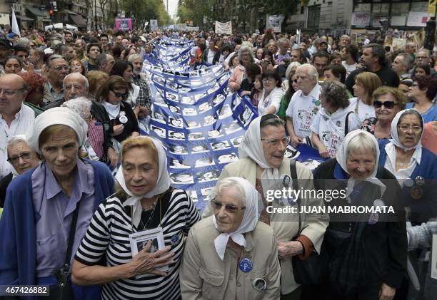 Members of the Madres de Plaza de Mayo Human Rights organization and demonstrators carry a large banner with portraits of people disappeared in the...