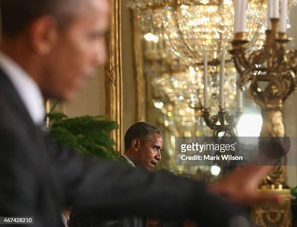 President Barack Obama is reflected in a mirror while speaking at a news conference with Afghan President Ashram Ghani in the East Room at the White...