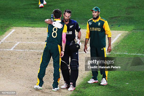 Imran Tahir of South Africa looks on as Grant Elliott of New Zealand hugs Dale Steyn of South Africa up after winning the 2015 Cricket World Cup Semi...