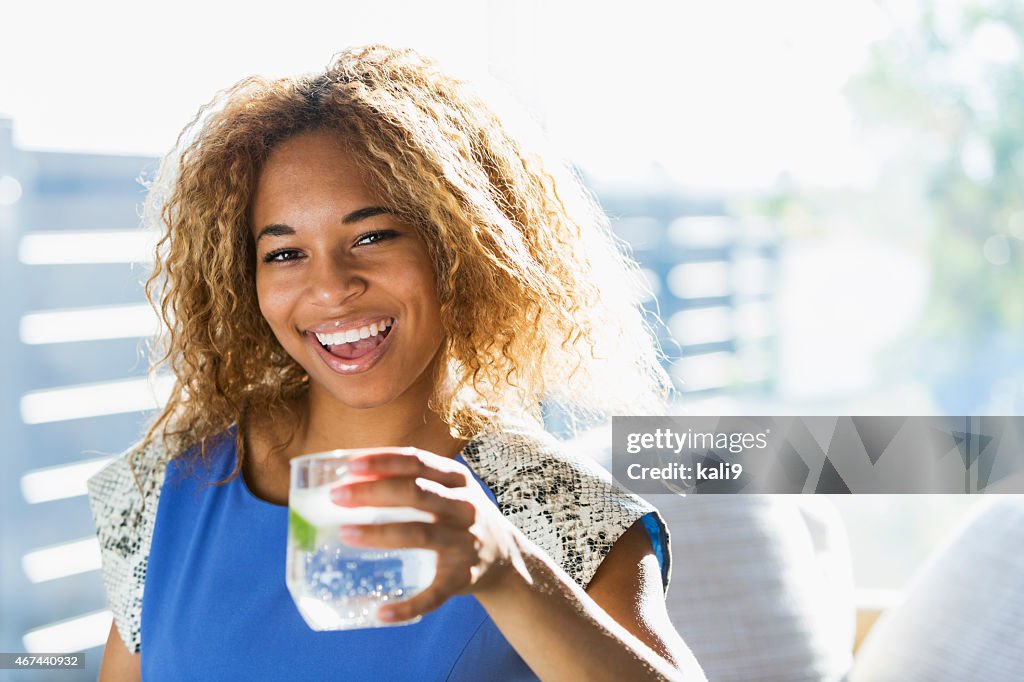 Beautiful African American teenage girl drinking water