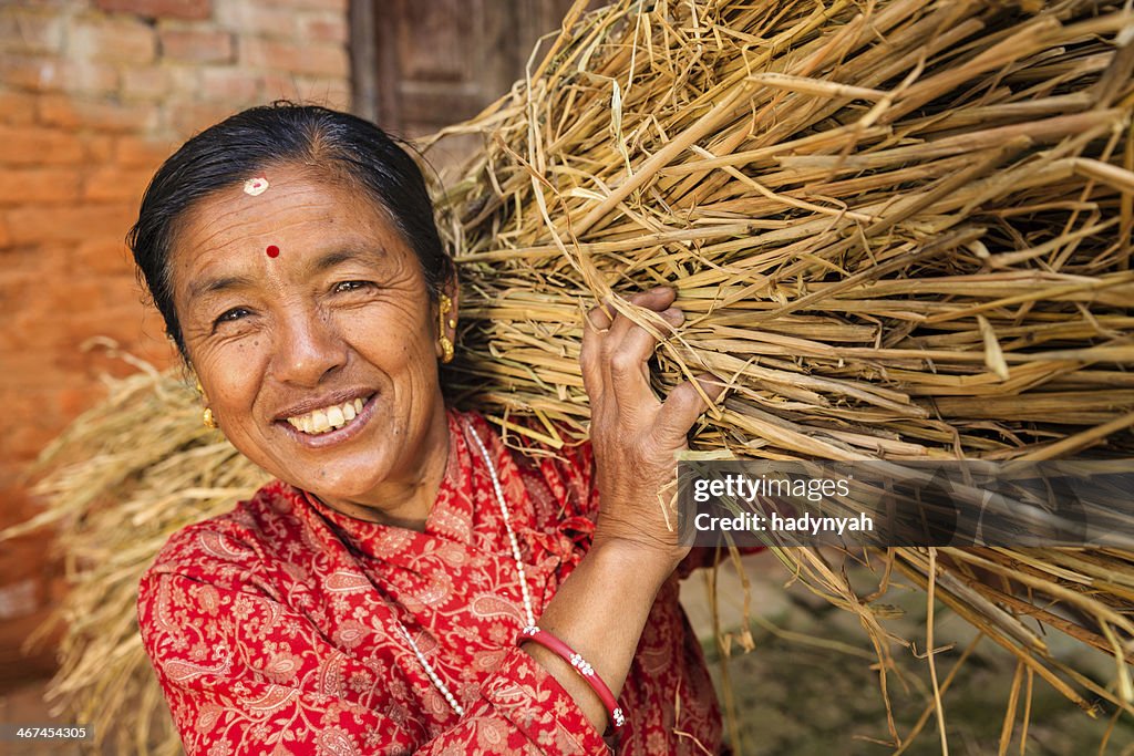 Le népalais femme porter le riz paille en Bhaktapour, Népal