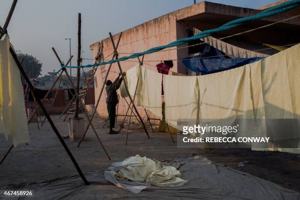 Indian washerman Sahamuddin and who goes by one name, hangs sheets to dry before sharing chai with other workers at a 'dhobi ghat' outdoor laundry in...