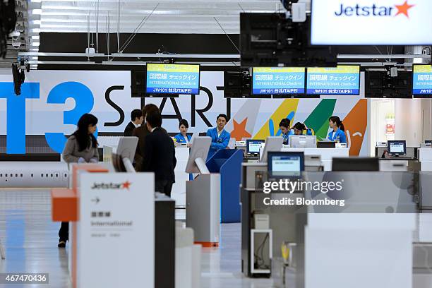 Vanilla Air ground staff stand behind a check-in counter in the Terminal 3 building of Narita Airport in Narita, Japan, on Wednesday, March 25, 2015....