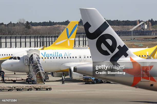 Jetstar Japan Co. Aircraft, right, passes a Vanilla Air aircraft at Terminal 3 of Narita Airport in Narita, Japan, on Wednesday, March 25, 2015. The...