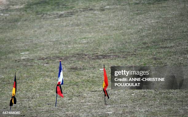 German, French and Spanish flags fly on March 25, 2015 in a field in the southeastern French village of Le Vernet, the closest to the site where the...