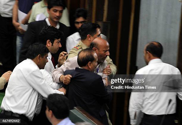Independent MLA Abdul Rashid being marshaled out during a Budget session on March 25, 2015 in Jammu, India. Jammu and Kashmir Assembly witnessed...