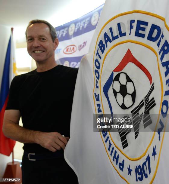 Thomas Dooley, former US football captain, poses for photos next to a Philippine Football Federation flag after a press conference in Manila on...