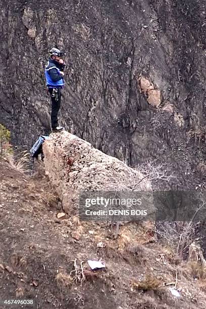 Screen grab taken from an AFP TV video on March 24, 2015 shows the a member of the search and rescue personnel standing on a rock at the crash site...