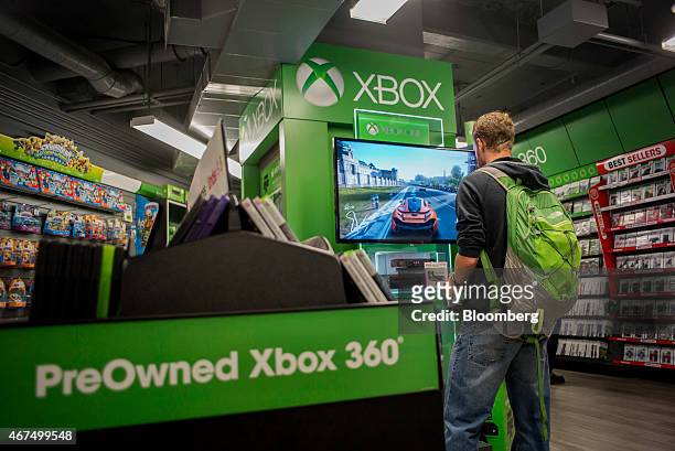 Customer plays a Microsoft Corp. Xbox 360 video game at a GameStop Corp. Store in San Francisco, California, U.S., on Tuesday March 24, 2015....