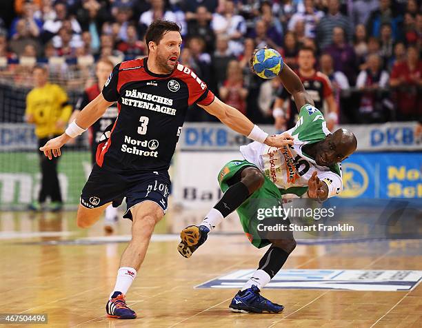 Tobias Karlsson of Flensburg is challenged by Kevynn Nyokas of Goeppingen during the DKB Bundesliga handball match between SG Flensburg-Handewitt and...