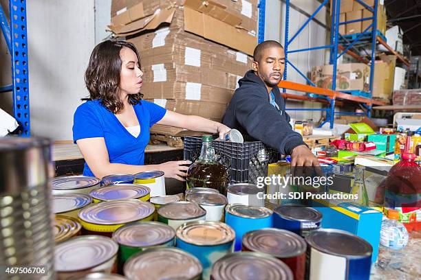 jovens volunteering para ordenar os donativos para caridade alimentos drive - recolha-de-alimentos imagens e fotografias de stock