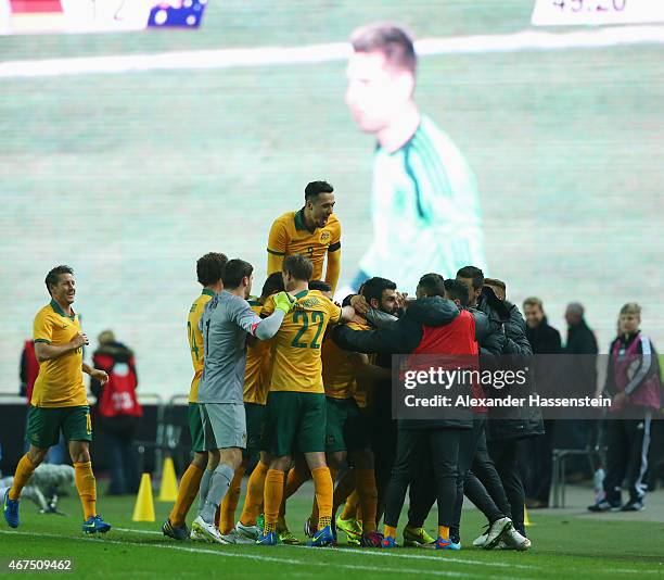Goalkeeper Ron-Robert Zieler of Germany is shown on the scoreboard as Mile Jedinak of Australia celebrates with team mates as he scores their second...