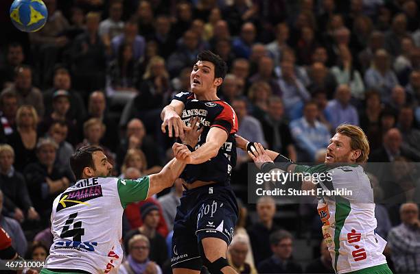 Drasko Nenadic of Flensburg is challenged by Manuel Späth and Tim Kneule of Goeppingen during the DKB Bundesliga handball match between SG...