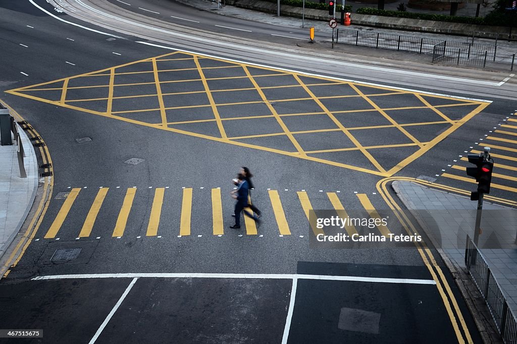 Two pedestrians crossing the street