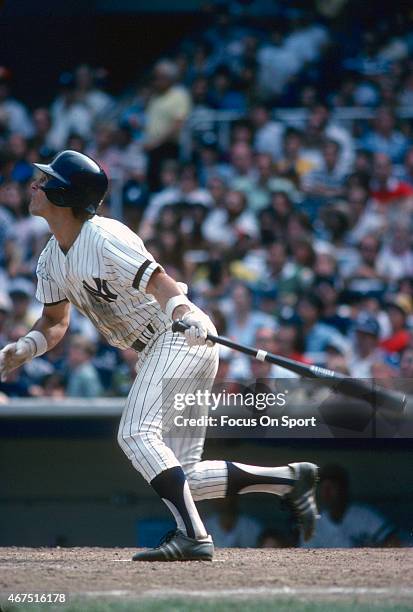 Bucky Dent of the New York Yankees swings and watches the flight of his ball during an Major League Baseball game circa 1980 at Yankee Stadium in the...