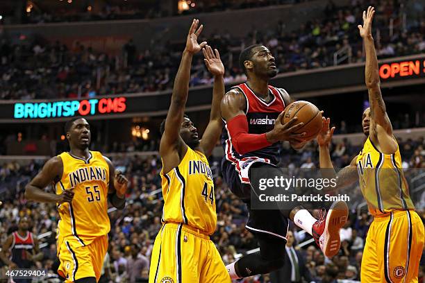 John Wall of the Washington Wizards puts up a shot between Solomon Hill and George Hill of the Indiana Pacers in the first half at Verizon Center on...