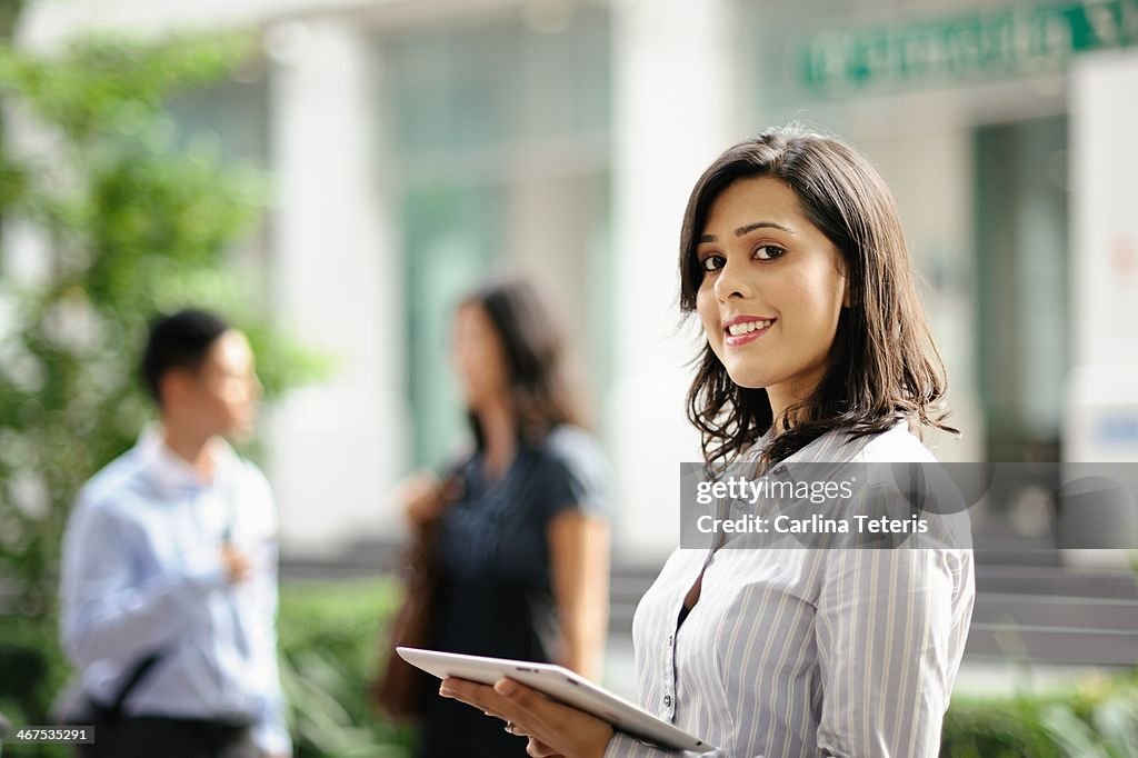 Young business woman holding a tablet outdoors