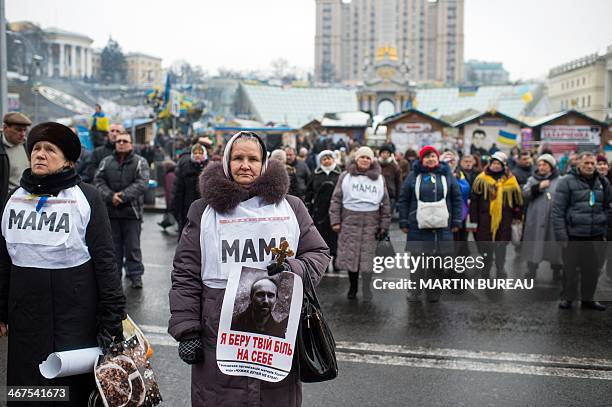 Women wearing bibs reading "mother" attend a mass on Kiev's Independence Square on February 7, 2014. Ukraine's unrest erupted in November 2013 after...