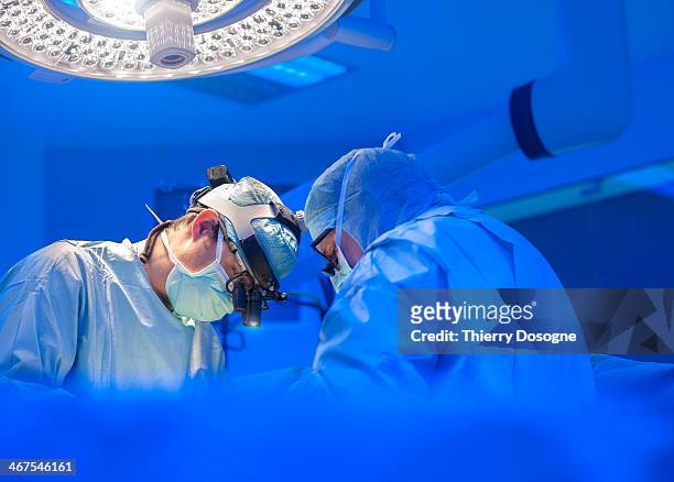 surgeons performing open heart surgery - surgery stock-fotos und bilder