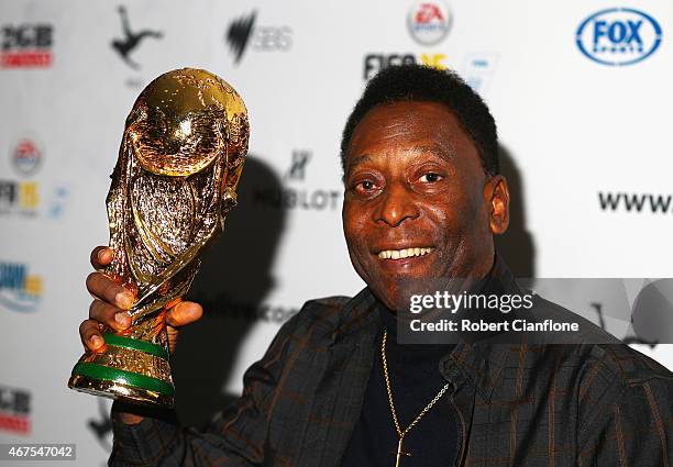 Pele holds a replica Wolrd Cup trophy during a press conference at The Peninsula on March 26, 2015 in Melbourne, Australia.