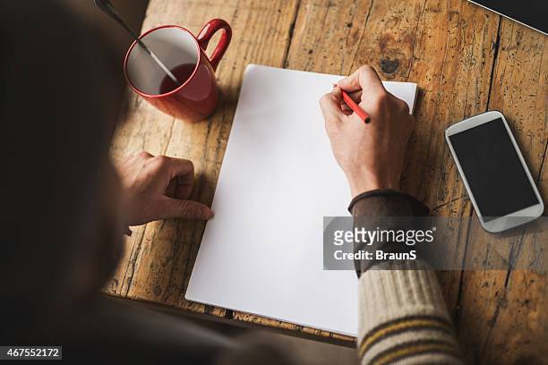 above view of unrecognizable person writing on paper. copy space - copy writing bildbanksfoton och bilder