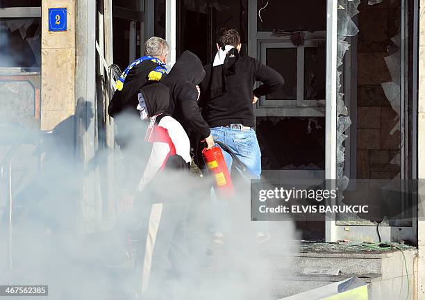 Protesters storm a local government building in the northern Bosnian town of Tuzla, on February 7, 2014. Several hundred protesters clashed with...