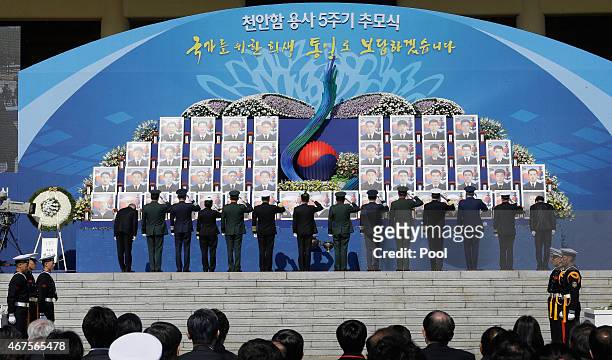 South Korea military officials salute before the portraits of the 46 deceased sailors from the sunken South Korean naval ship Cheonan during a...