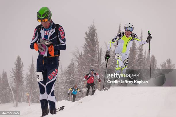 Four ski mountaineering racers during a race at the Jackson Hole Mountain Resort. Three are on ski's and one is in transition rolling up his climbing...